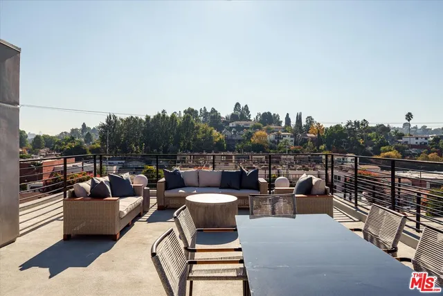 a view of a roof deck with couches and potted plants