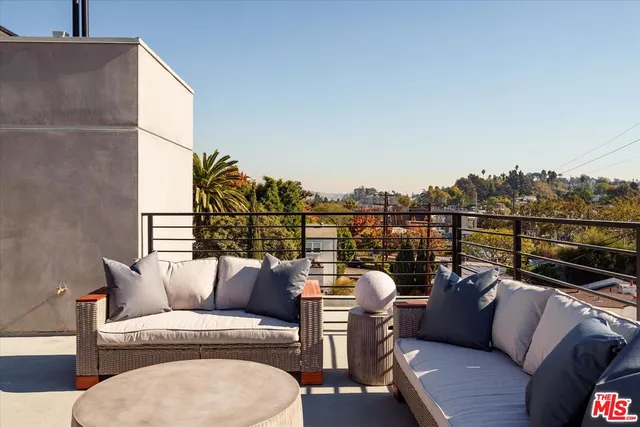 a balcony with wooden floor and outdoor seating