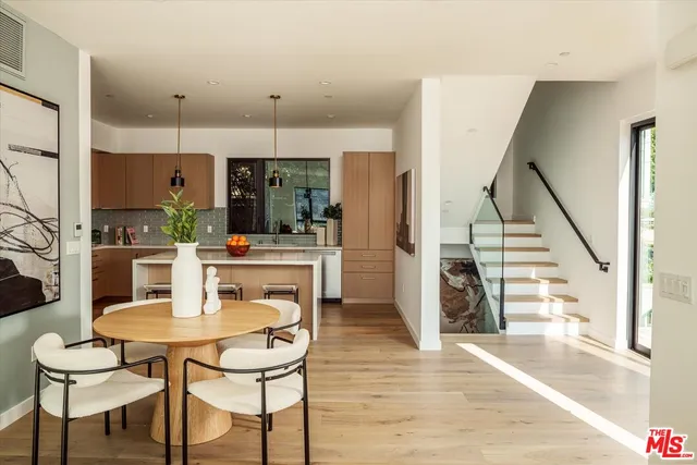 a kitchen with stainless steel appliances kitchen island granite countertop a table and chairs in it