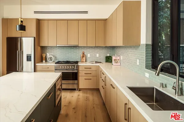a kitchen with white cabinets sink and stainless steel appliances
