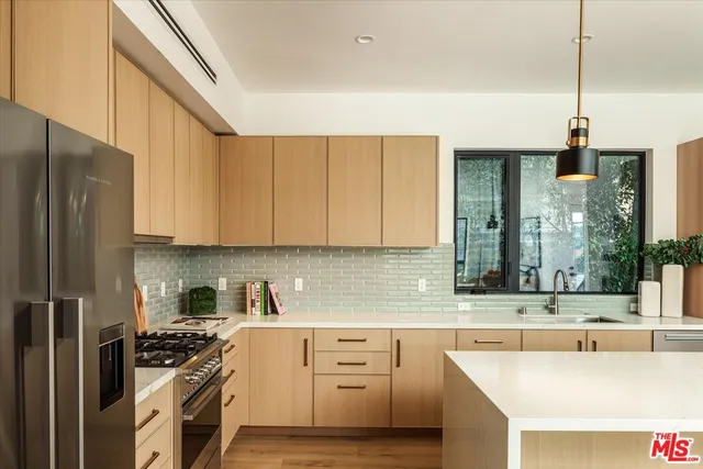a kitchen with a refrigerator a sink and white cabinets