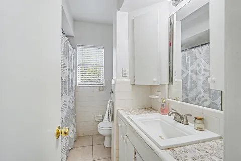 a bathroom with a sink a toilet and a window