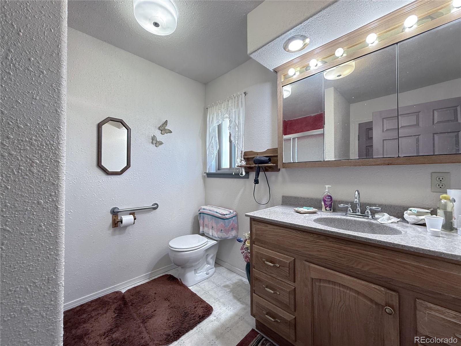 20899 County Rd L.7 San Luis, CO 81152 - Photo 15 of 36 a bathroom with a toilet sink double vanity and mirror