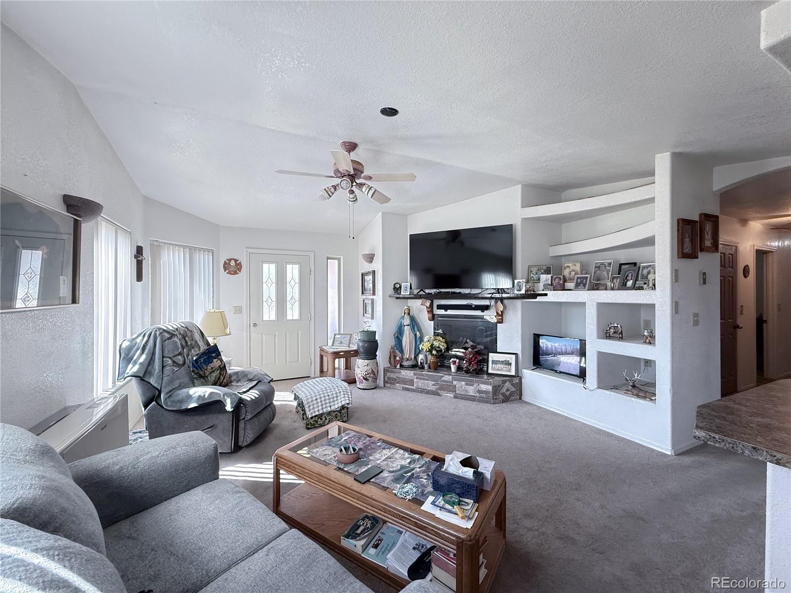 20899 County Rd L.7 San Luis, CO 81152 - Photo 9 of 36 a living room with furniture and a flat screen tv with kitchen view