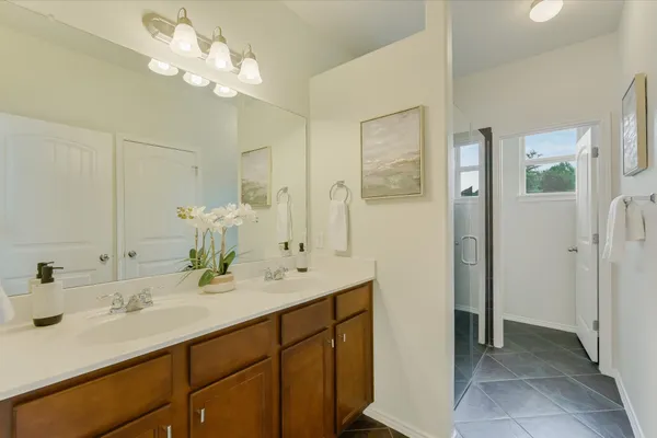 a bathroom with a sink vanity granite shower and a mirror