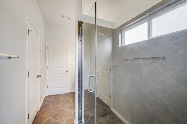 a bathroom with a shower and a glass door