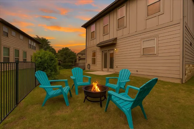 a backyard of a house with barbeque oven table and chairs