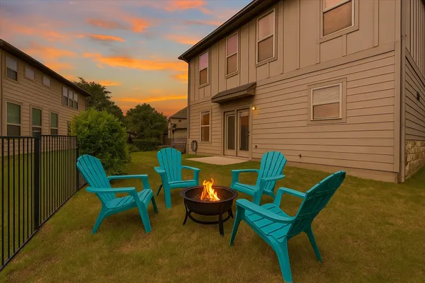 a backyard of a house with barbeque oven table and chairs