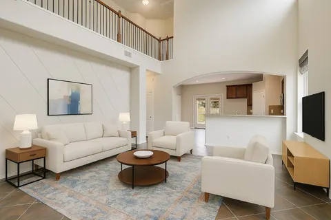 a living room with furniture a rug and a flat screen tv