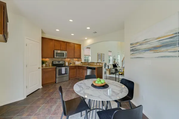 a kitchen with a dining table chairs and refrigerator