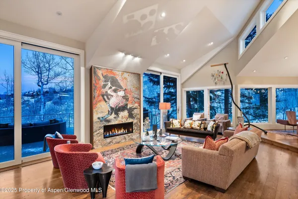 a living room with fireplace furniture and a large window