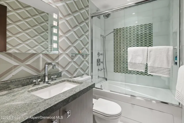 a bathroom with a toilet sink and shower