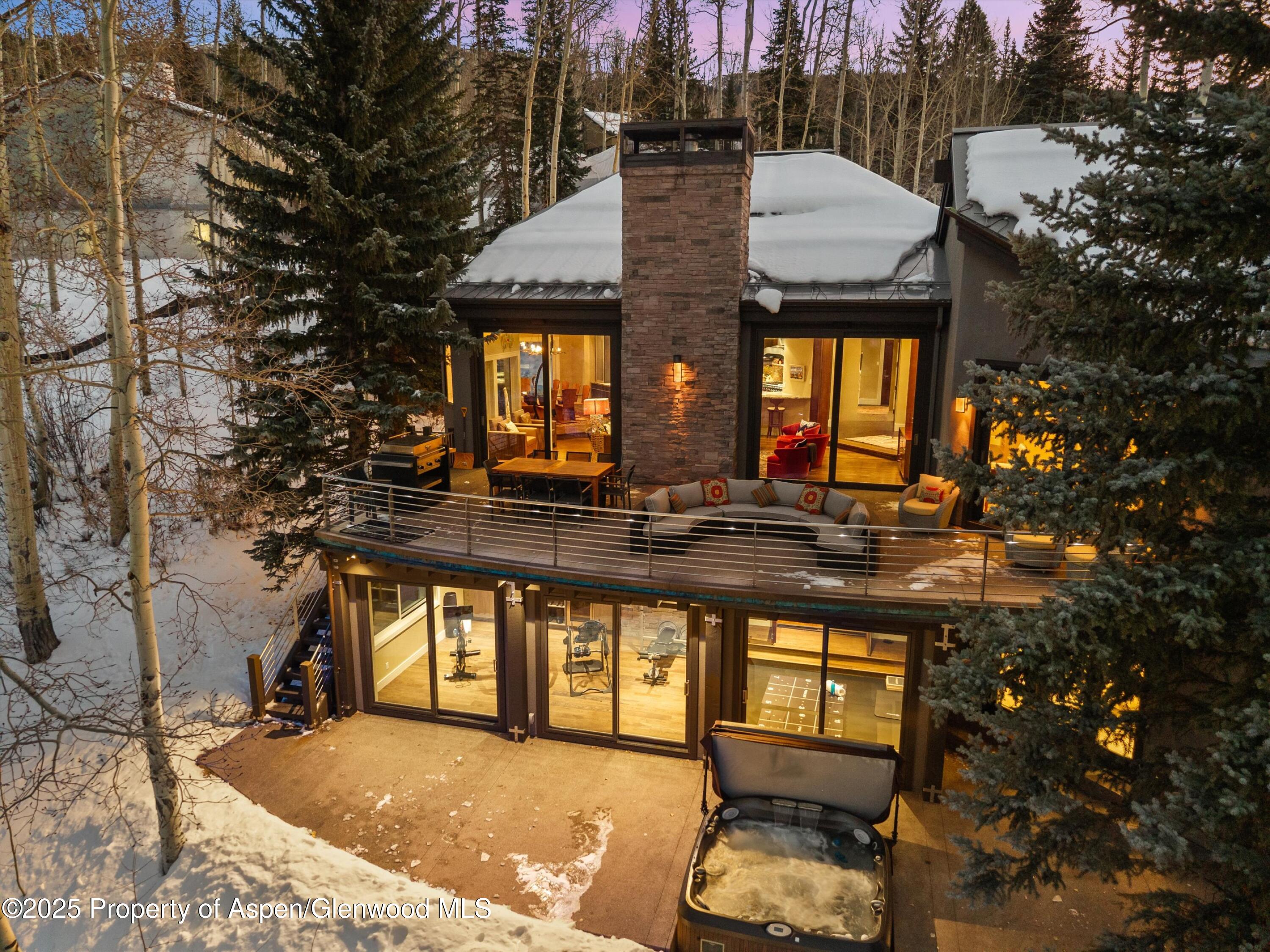 1248 Wood Road Snowmass Village, CO 81615 - Photo 4 of 43 a backyard of a house with barbeque oven table and chairs