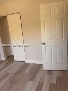 8741 Wiles Road, Unit 208 Coral Springs, FL 33067 - Photo 7 of 11 an empty room with wooden floor and white wall