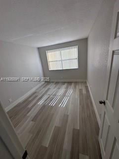 8741 Wiles Road, Unit 208 Coral Springs, FL 33067 - Photo 8 of 11 wooden floor in an empty room with a window