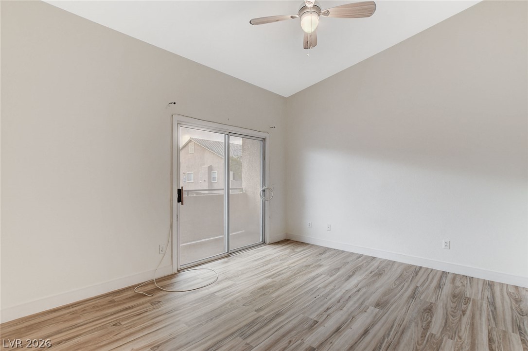 2052 Quarry Ridge Street, Unit 201 Las Vegas, NV 89117 - Photo 15 of 25 A well-lit room with vaulted ceilings and wide plank flooring offers direct outdoor access.