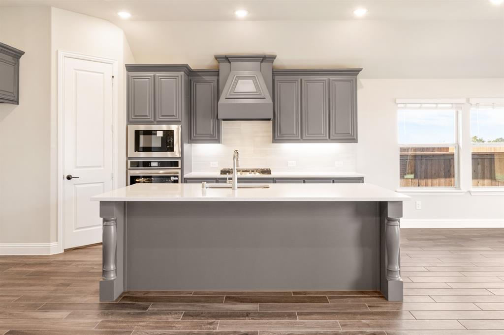 14426 McClint Street Pilot Point, TX 76258 - Photo 11 of 34 a kitchen with kitchen island a counter top space a sink and appliances