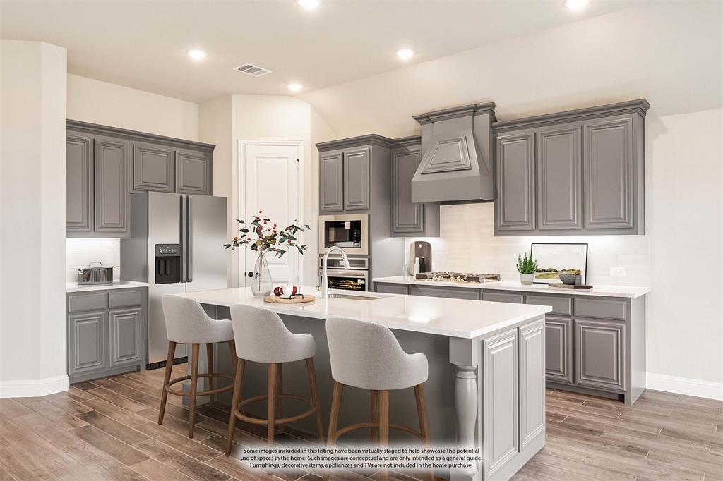 14426 McClint Street Pilot Point, TX 76258 - Photo 13 of 34 a kitchen with kitchen island granite countertop a sink and refrigerator