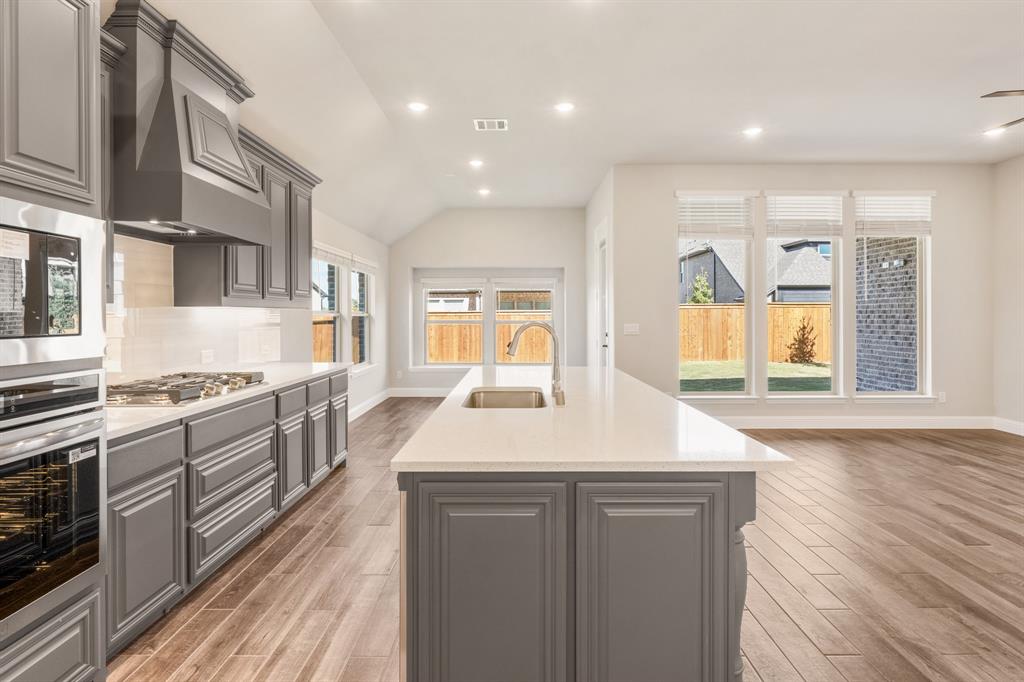 14426 McClint Street Pilot Point, TX 76258 - Photo 15 of 34 a large kitchen with stainless steel appliances granite countertop a lot of counter space and wooden floors