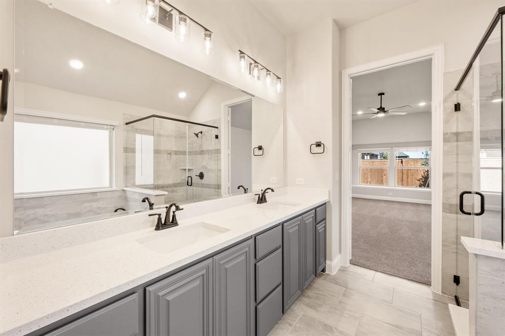 14426 McClint Street Pilot Point, TX 76258 - Photo 22 of 34 a bathroom with a sink double vanity and a shower