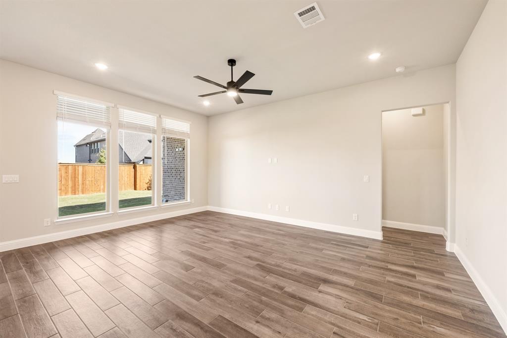 14426 McClint Street Pilot Point, TX 76258 - Photo 7 of 34 a view of an empty room with a window and wooden floor