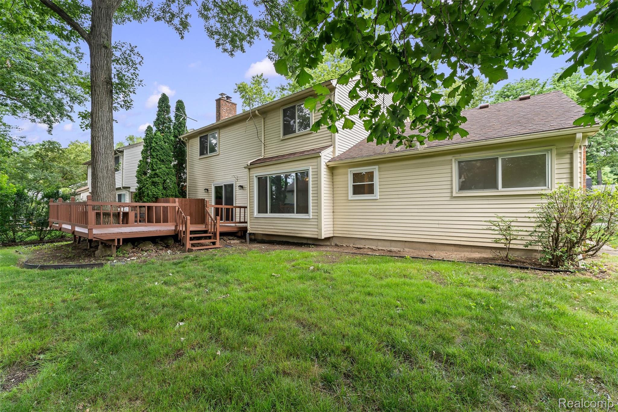 2118 Rutgers Drive Troy, MI 48085 - Photo 39 of 39 Expansive grassy yard with mature trees and a multi-level wood deck