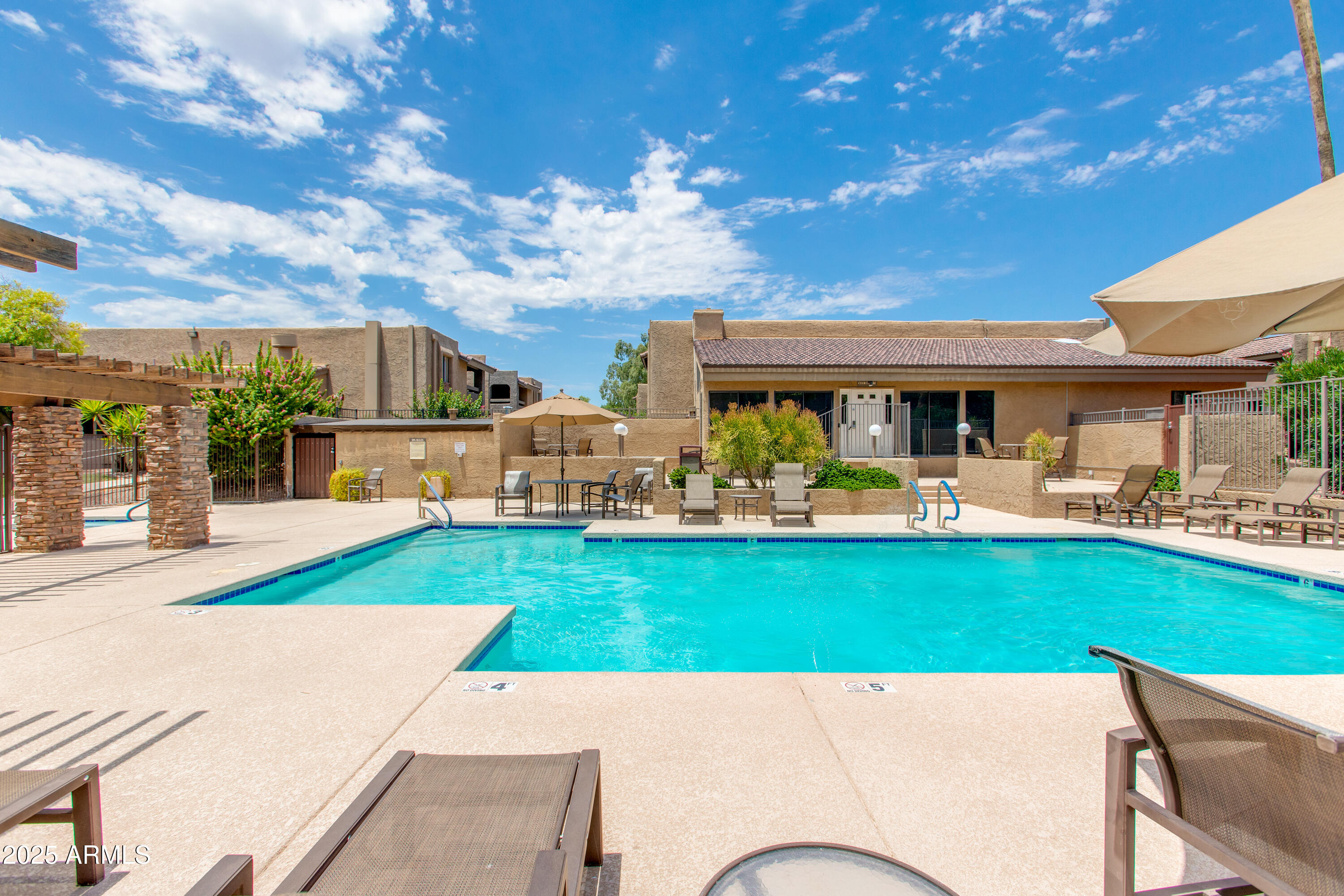 3825 East Camelback Road, Unit 105 Phoenix, AZ 85018 - Photo 11 of 14 a view of a house with a swimming pool and a yard