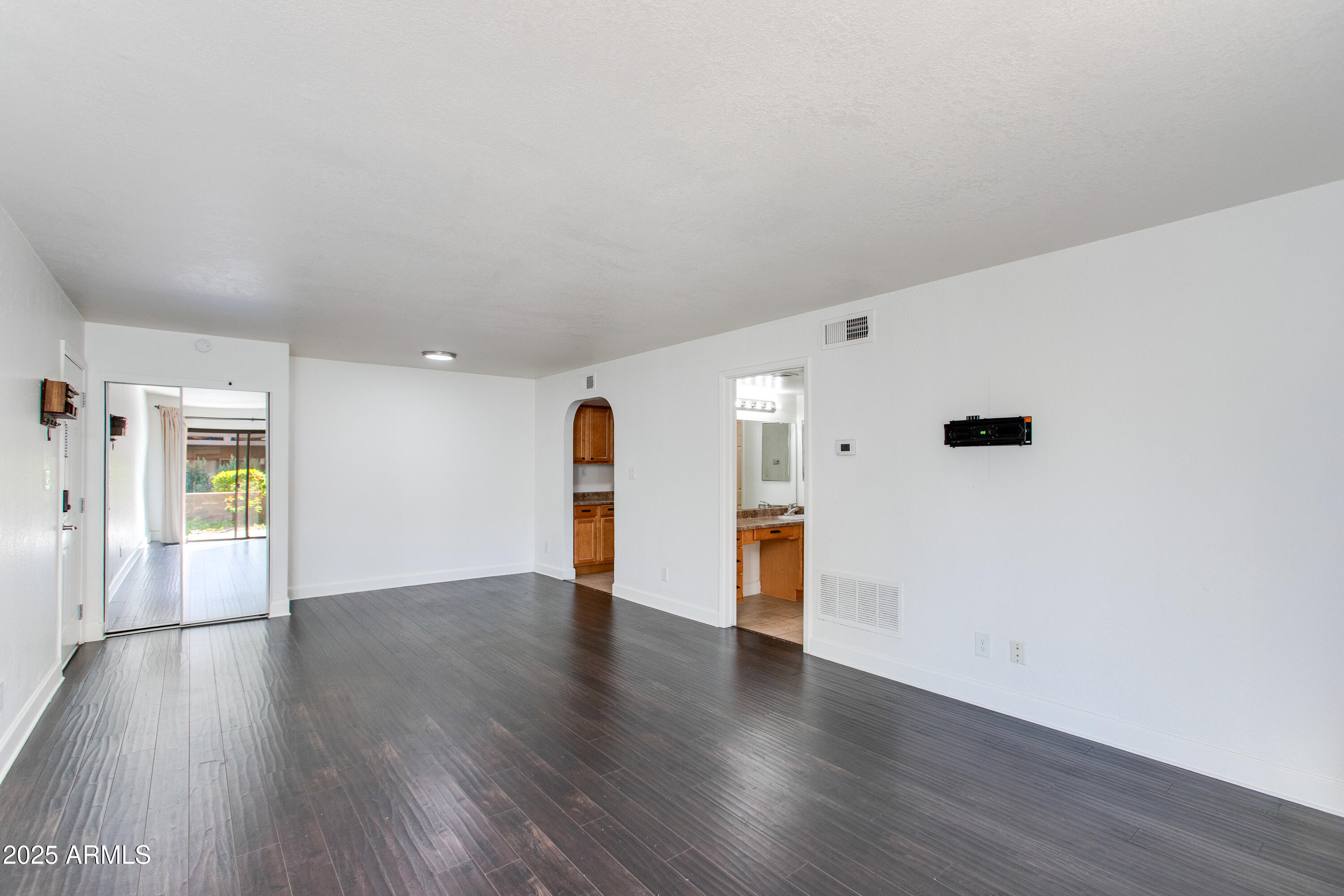 3825 East Camelback Road, Unit 105 Phoenix, AZ 85018 - Photo 3 of 14 an empty room with wooden floor and windows