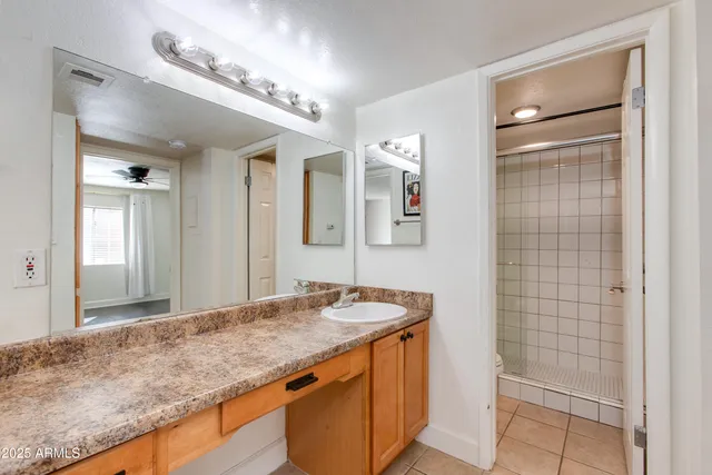 a bathroom with a granite countertop sink and a mirror