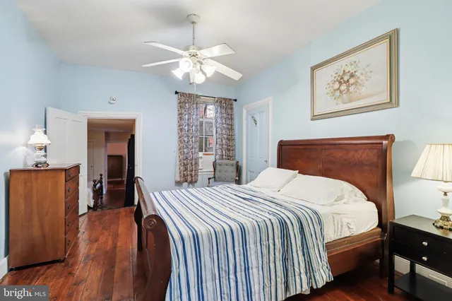 a bedroom with bed and wooden floor
