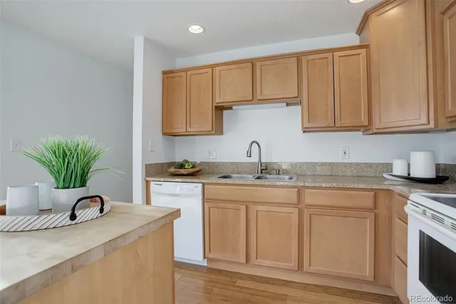 a kitchen with granite countertop a sink stove and cabinets