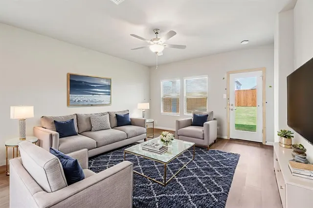 a living room with furniture a flat screen tv and a window
