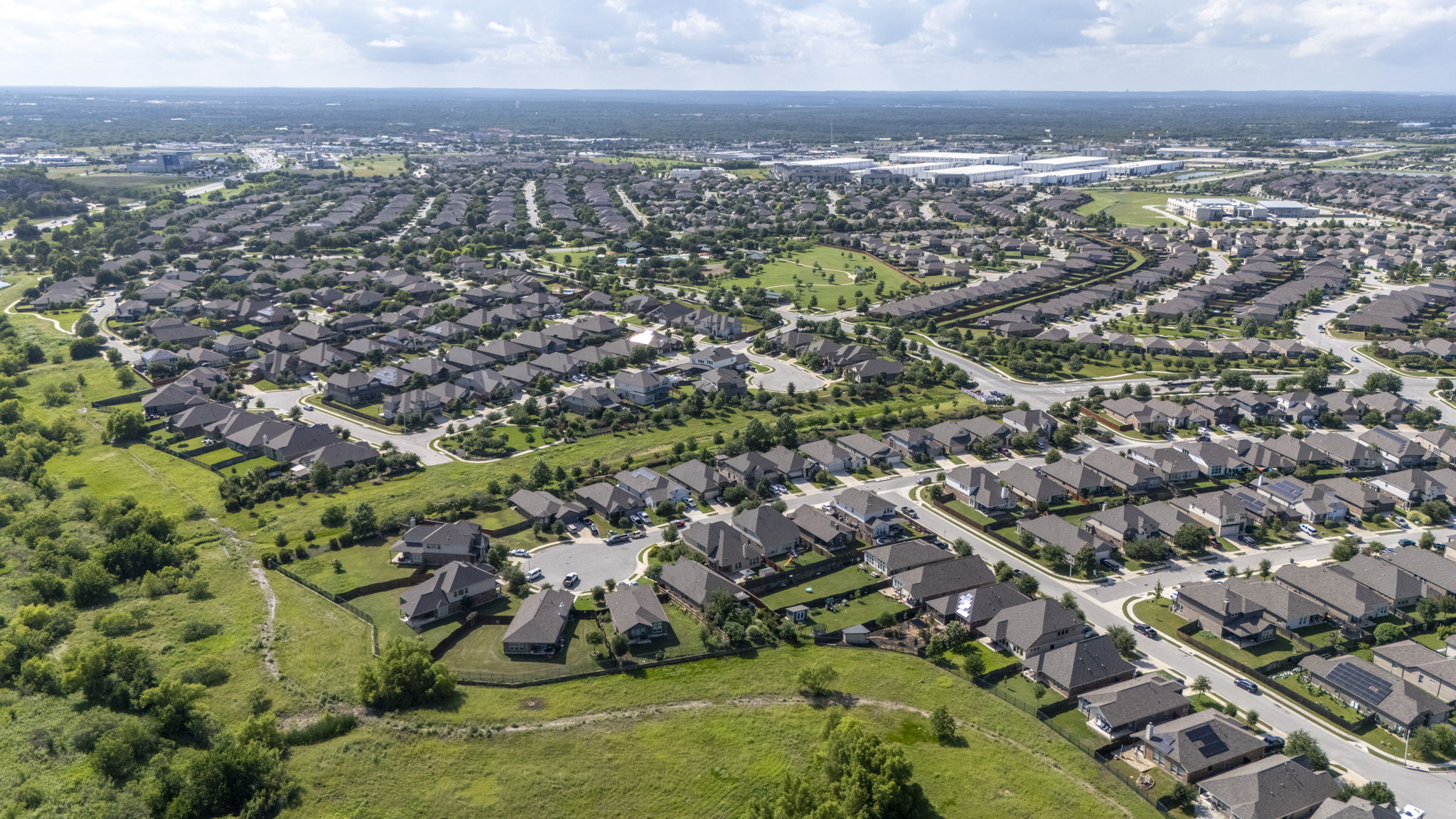 373 Rough Bark Street Buda, TX 78610 - Photo 33 of 39 An aerial panorama reveals a vast, well-planned suburban community with abundant green spaces.