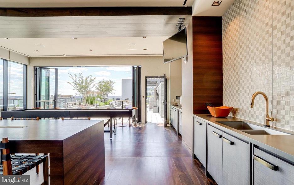 70 N Street Southeast, Unit N913 Washington, DC 20003 - Photo 47 of 77 a open kitchen with stainless steel appliances a large counter top a stove and a wooden floors