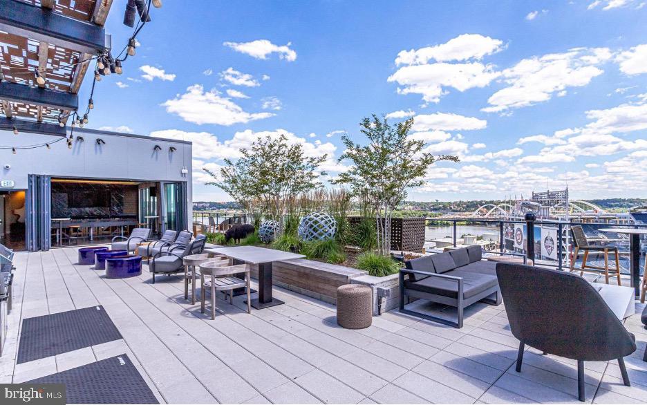 70 N Street Southeast, Unit N913 Washington, DC 20003 - Photo 56 of 77 a view of a patio with dining table and chairs with a barbeque grill and a fireplace