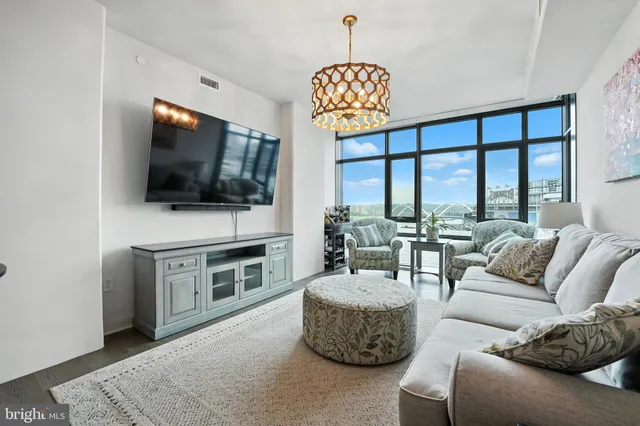 a large kitchen with kitchen island a refrigerator a stove a sink dishwasher a dining table and chairs with wooden floor