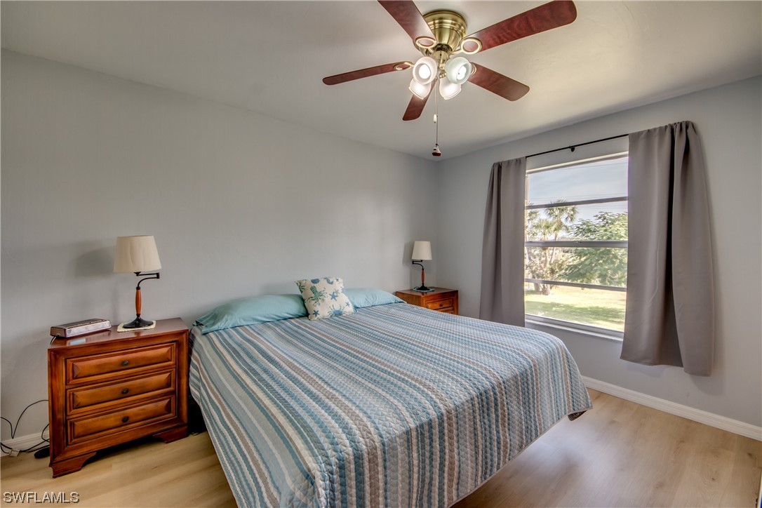 1100 Pondella Road, Unit 814 Cape Coral, FL 33909 - Photo 15 of 36 a bedroom with a bed and a chandelier