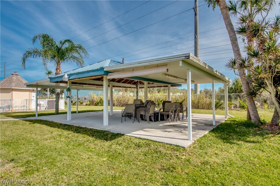 1100 Pondella Road, Unit 814 Cape Coral, FL 33909 - Photo 31 of 36 a view of a patio with a table and chairs under an umbrella