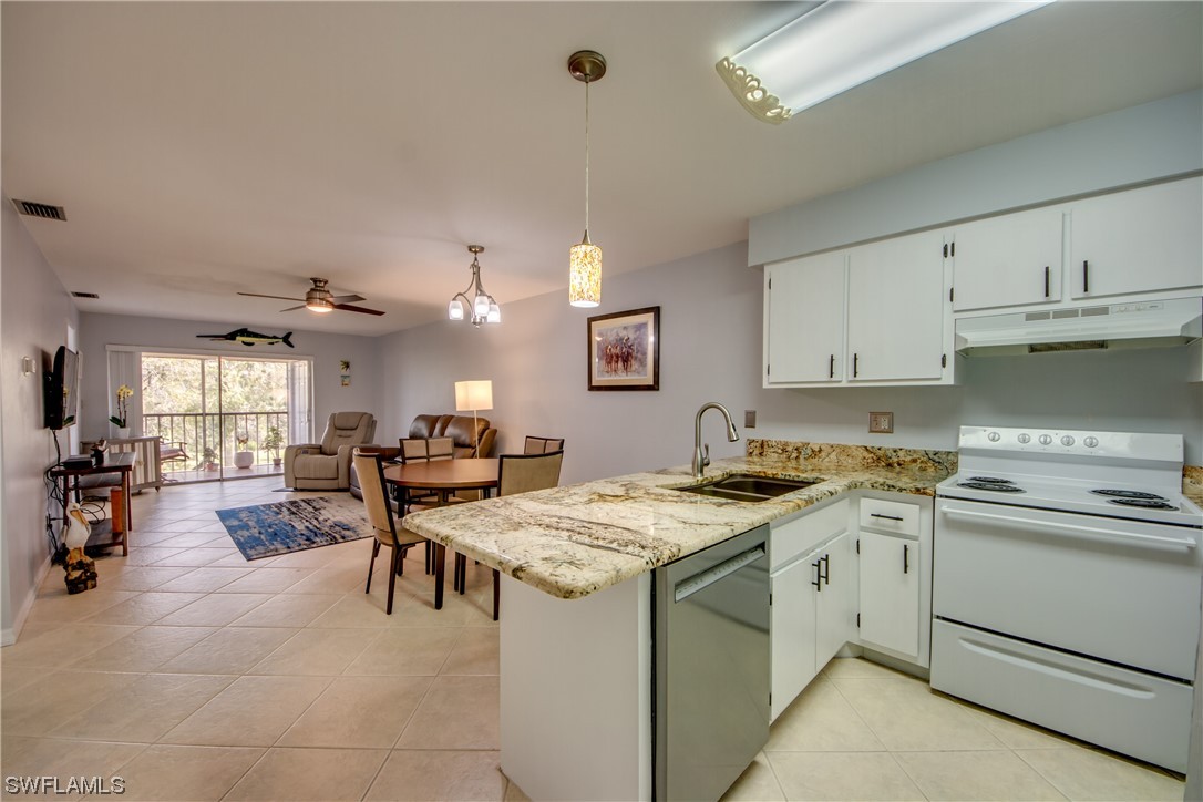 1100 Pondella Road, Unit 814 Cape Coral, FL 33909 - Photo 5 of 36 a kitchen with a stove a sink a dining table and chairs