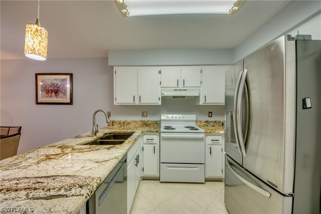 1100 Pondella Road, Unit 814 Cape Coral, FL 33909 - Photo 6 of 36 a kitchen with stainless steel appliances granite countertop a refrigerator sink and stove