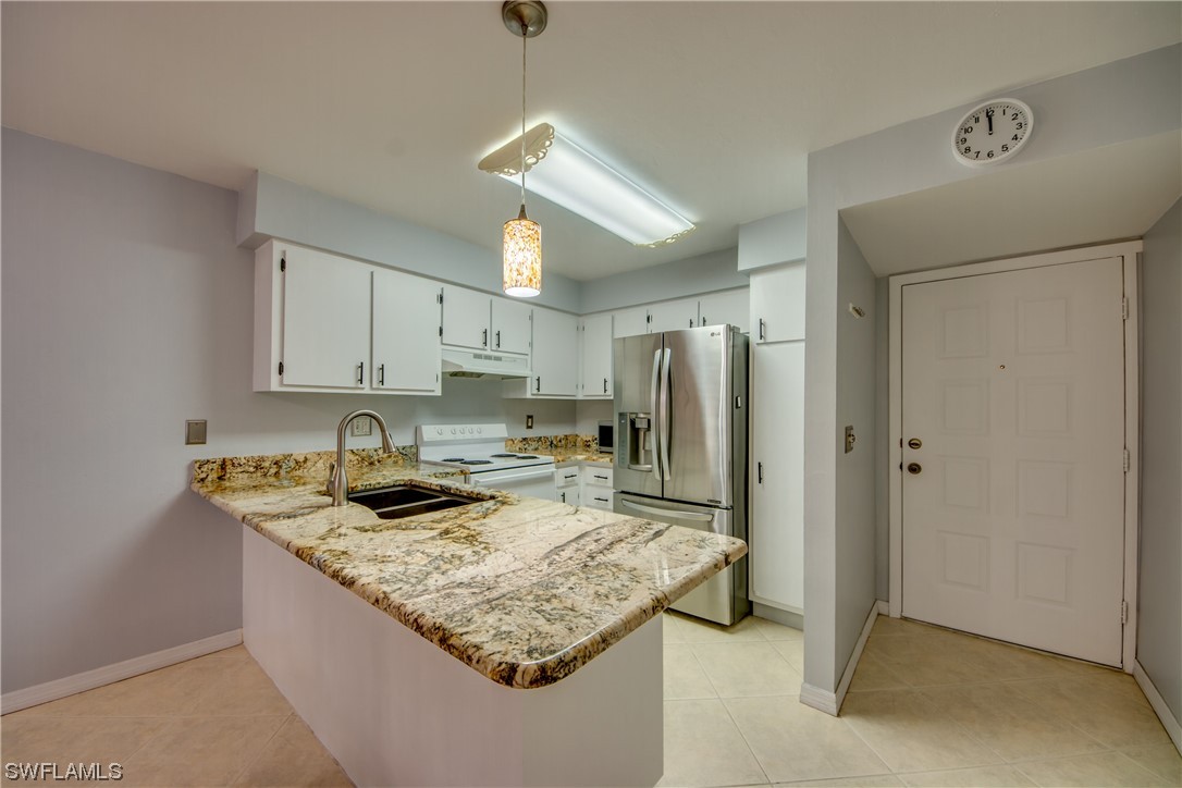 1100 Pondella Road, Unit 814 Cape Coral, FL 33909 - Photo 8 of 36 a kitchen with stainless steel appliances granite countertop a sink refrigerator and cabinets
