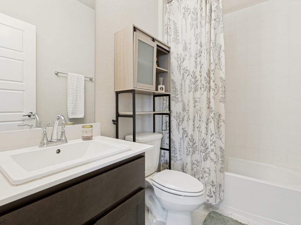 10613 Smiths Bnd Road Fort Worth, TX 76126 - Photo 20 of 29 White vanity with an integrated sink, polished chrome faucet, and dark wood-finish cabinetry