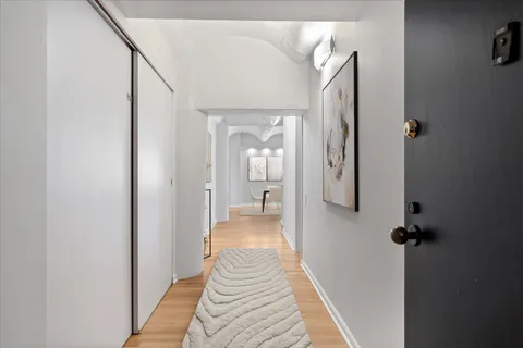 a view of a hallway with wooden floor and staircase