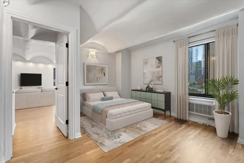 a bedroom with a bed and a potted plant