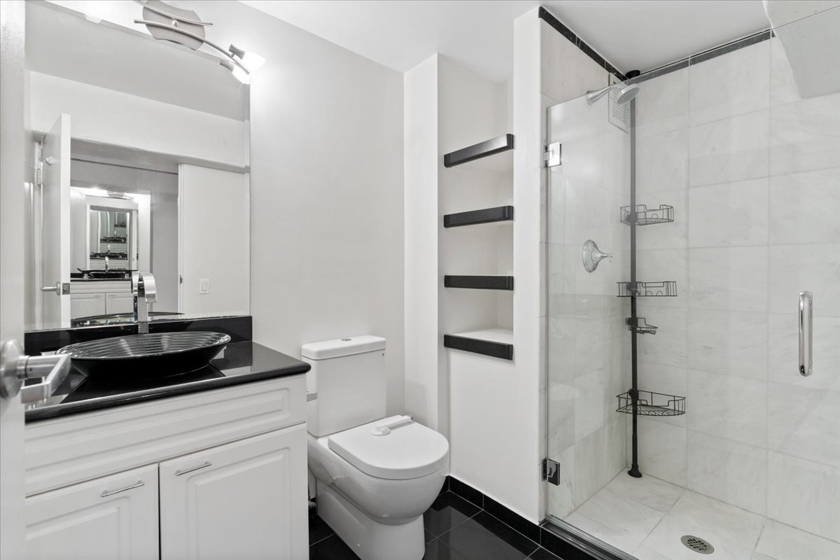 345 North Canal Street, Unit 608 Chicago, IL 60606 - Photo 24 of 27 a bathroom with a granite countertop sink a toilet and shower