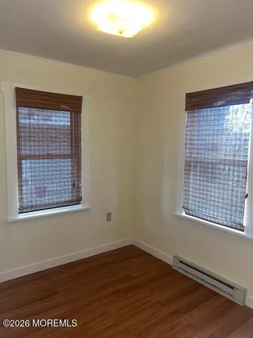 an empty room with wooden floor and a window