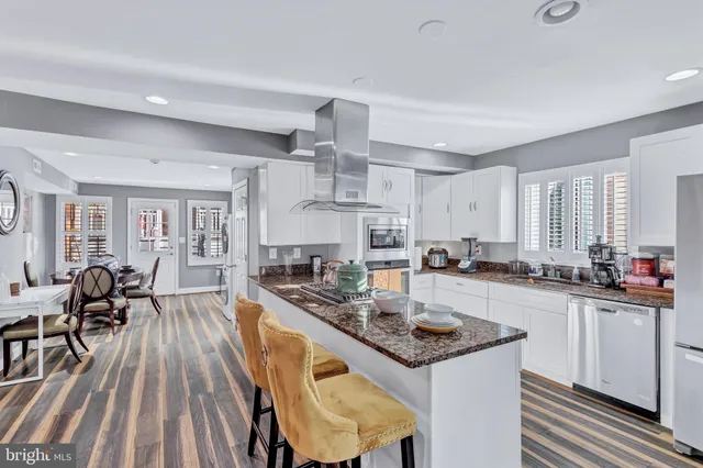 a kitchen with sink a stove and chairs