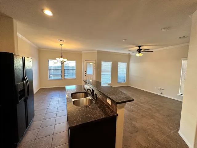 a kitchen with stainless steel appliances granite countertop a refrigerator and a stove top oven