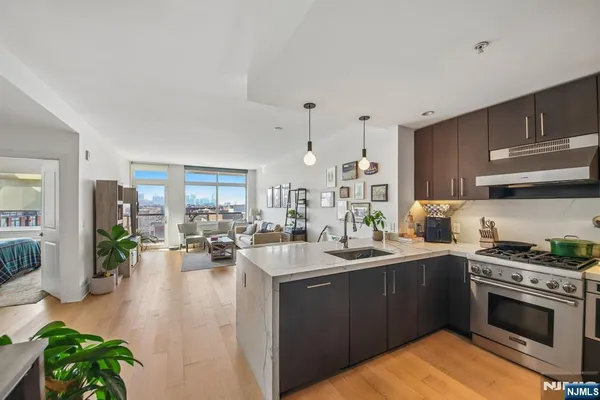 a kitchen with stainless steel appliances granite countertop a stove a sink and a refrigerator