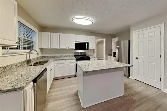 a kitchen with granite countertop counter top space a sink stainless steel appliances and cabinets